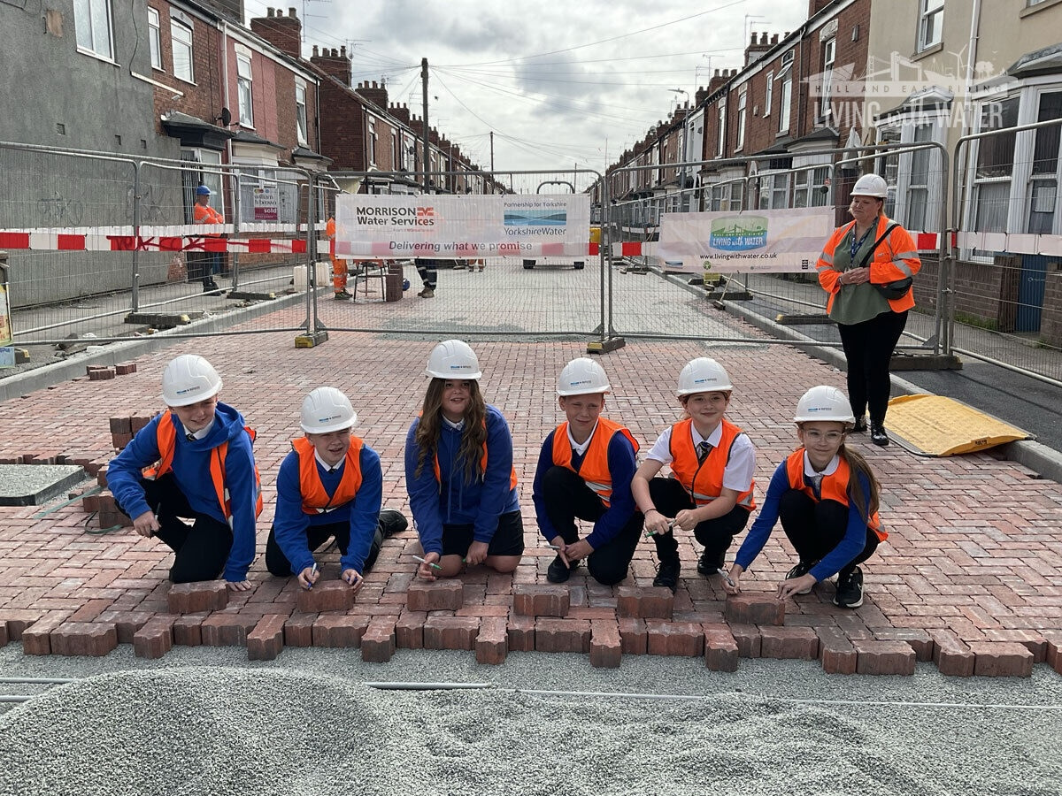 A photo of six school children laying some bricks as part of the permeable paving on Rosemead Street