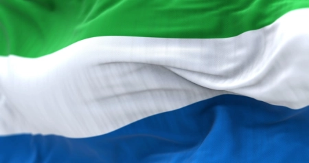 Detail of the Sierra Leone national flag waving in the wind. Tricolor with horizontal stripes in green, white and blue. Fabric textured background. Selective focus. 3D illustration render. Close-up