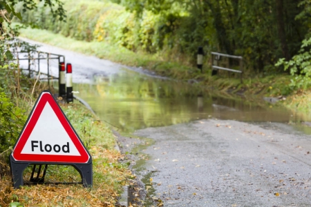 Flooded country road in England, UK with a flood road sign