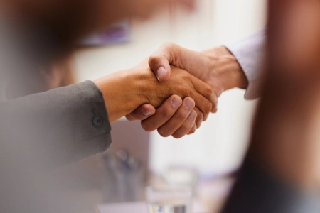 Close up of unrecognizable business colleagues shaking hands in the office.